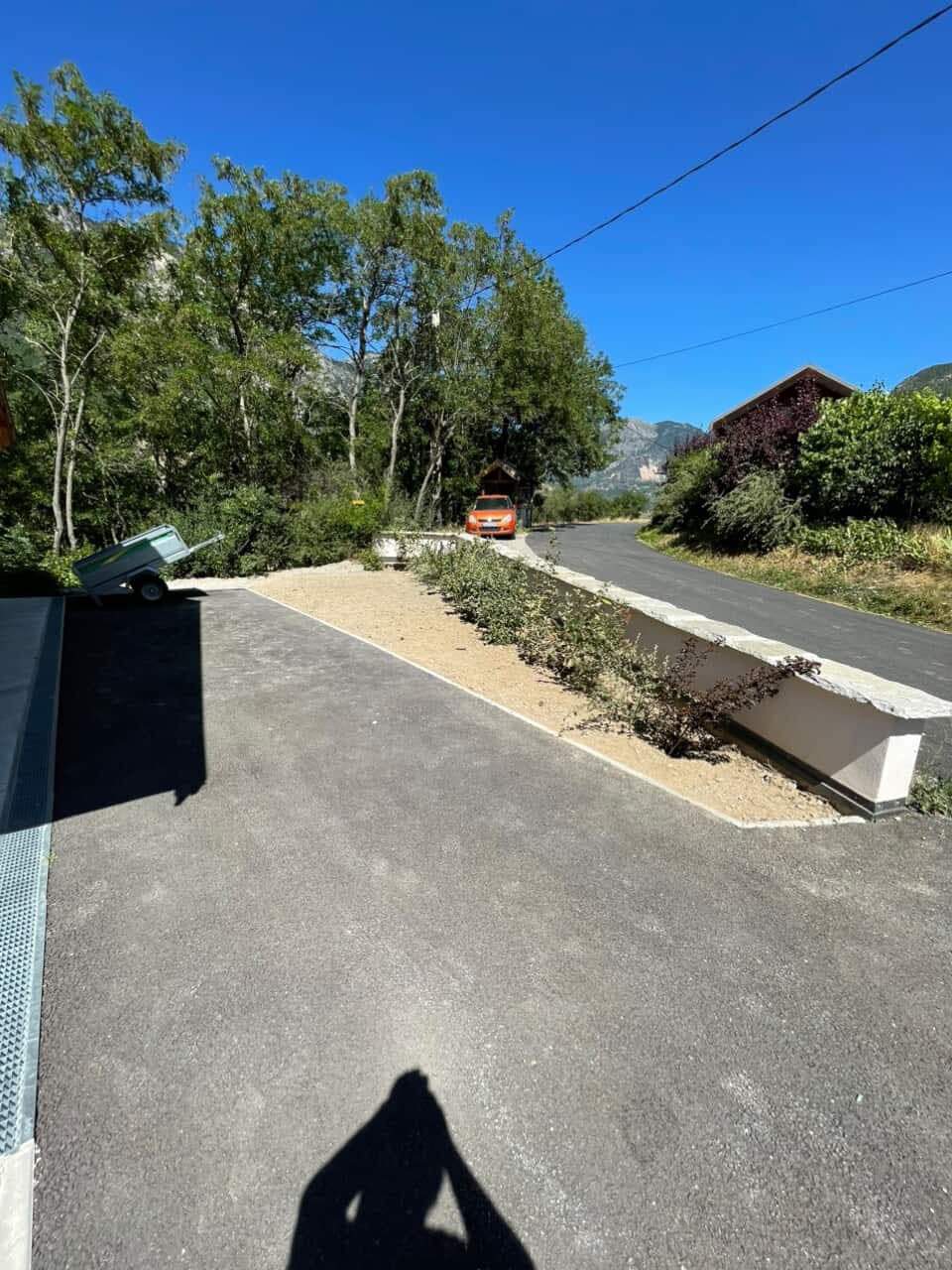 Allée en gravier terminée avec bordures béton, vue sur les montagnes